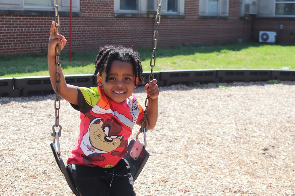 Preschool student on a playground swing