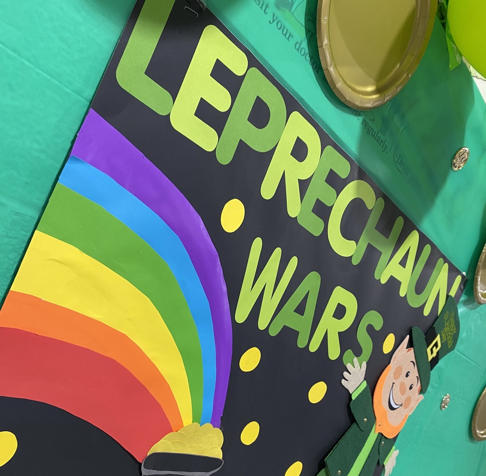 Billboard with Leprechaun Wars title and decorated with a leprechaun and pot of gold at the end of a rainbow