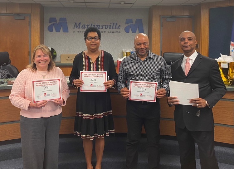 Three members of Martinsville City School Board stand with MCPS Superintendent in Martinsville city council chambers. Each school board member holds a certificate acknowledging school board appreciation month. 