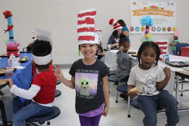 Clearview students eating green eggs and ham in Dr. Seuss hats