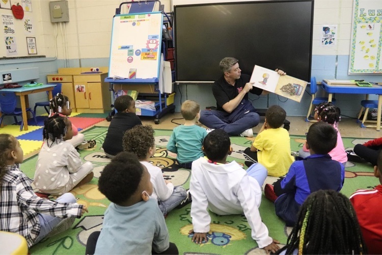 MCPS coordinator of advanced learning Cary Wright reads to a group of preschool students  