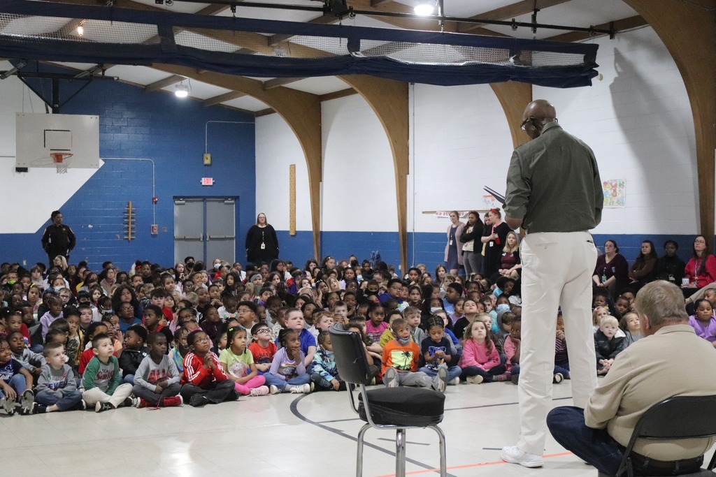 George Bell speaks to all of Patrick Henry Elementary School in the gym as students are seated on the floor