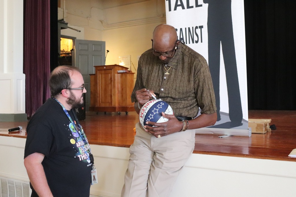 George Bell signs a Harlem Globetrotter basketball for art teacher Wenn Harold