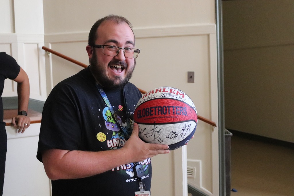 AHES art teacher Mr. Wenn holds a basketball signed by George Bell