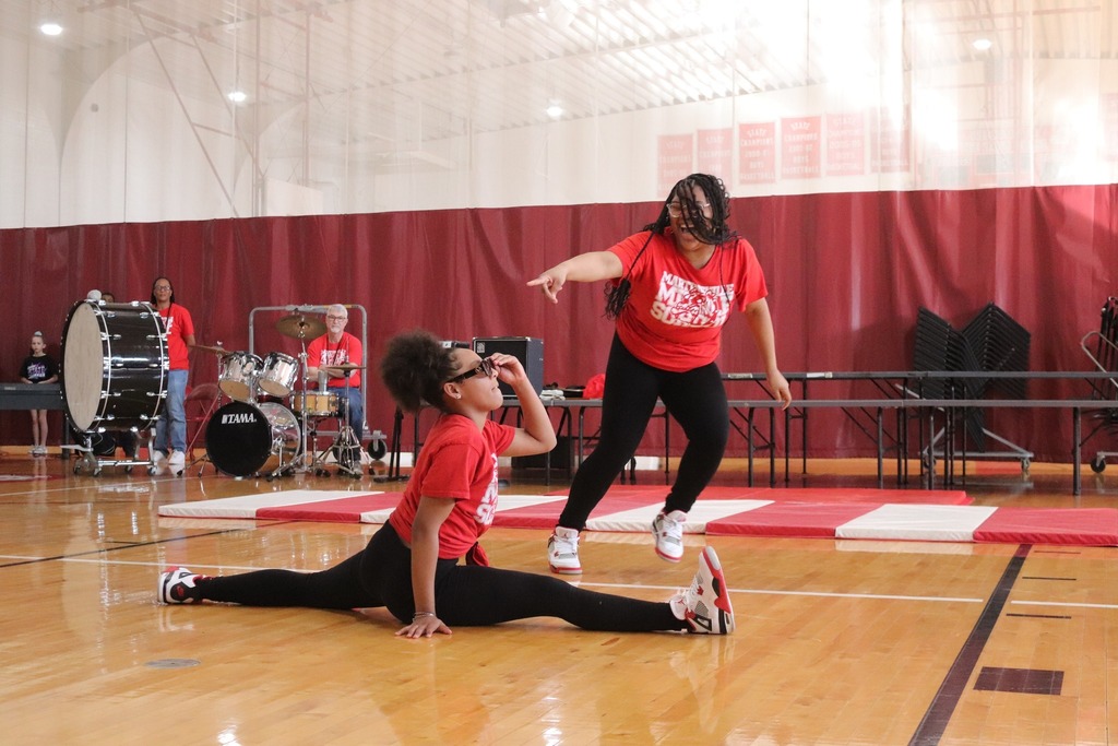 One MMS student points and smiles as her dance partner does a split during the talent show