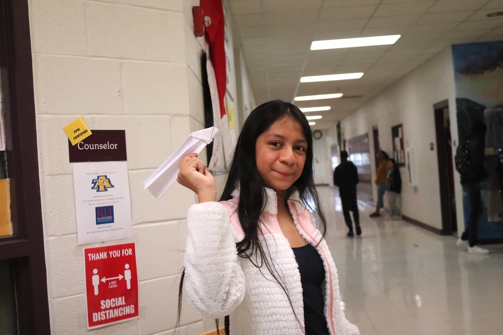 MMS student holds a paper airplane