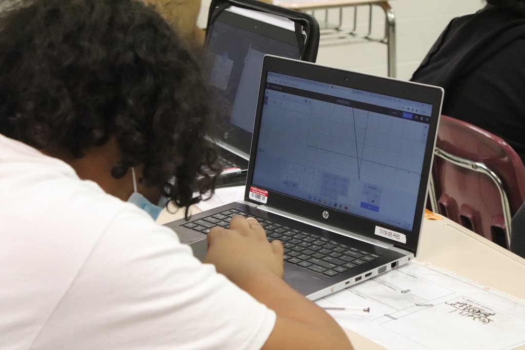 A student graphs a math problem on a laptop