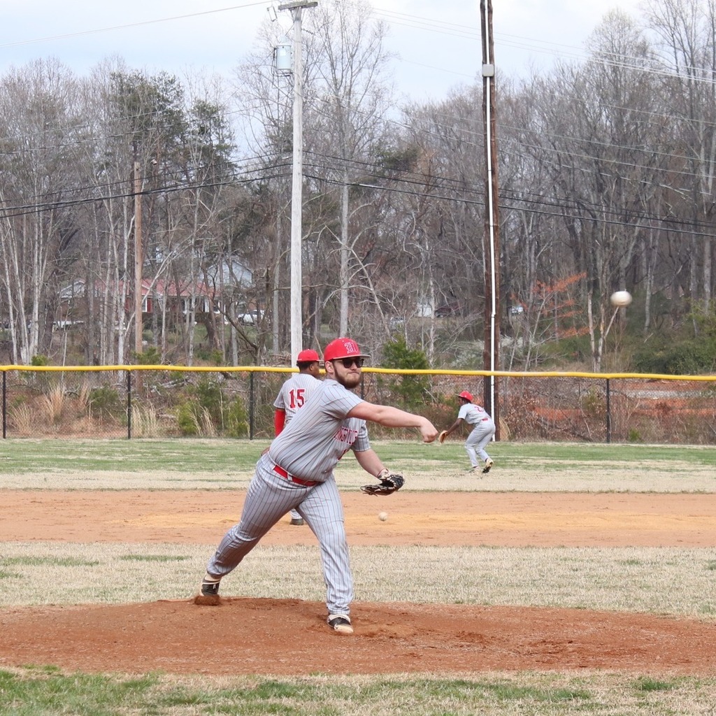A high school baseball pitcher throws the ball