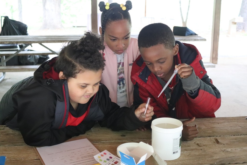 AHES students hold test tubes for water quality testing