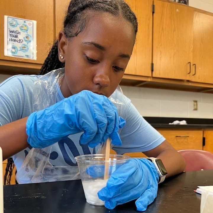 student making flubber in a science lab