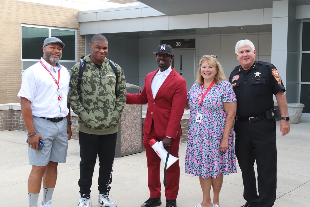 MHS principal, school board chair, school board member, and Martinsville police chief pose with a student outside of Martinsville High School