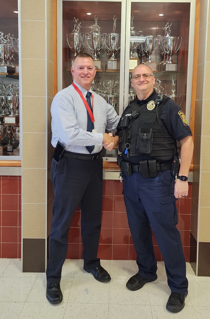School resource officer Shane McPeek shakes hands with MCPS School Safety Director TJ Slaughter